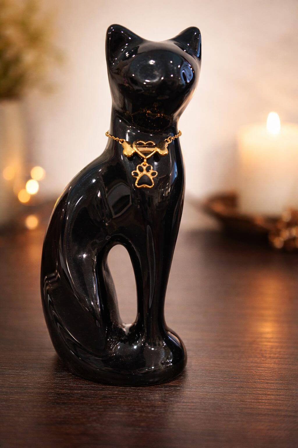 Elegant brass cat-shaped pet cremation urn with a glossy black finish